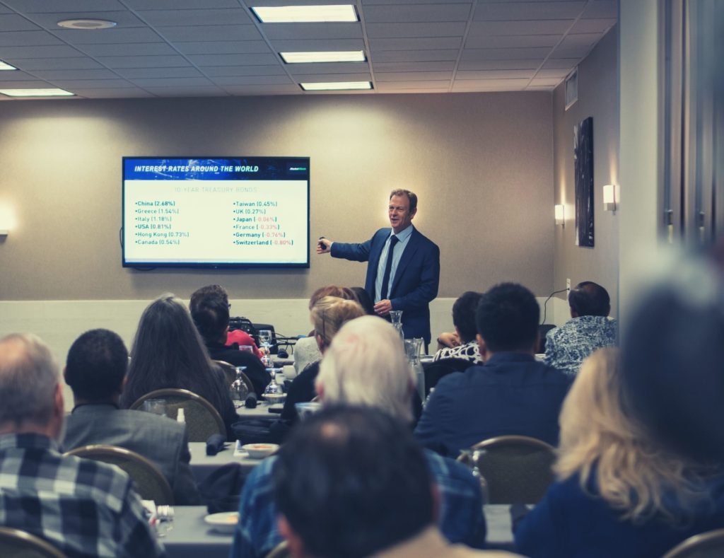 A Triple Net Lease Specialist giving a seminar to a packed classroom