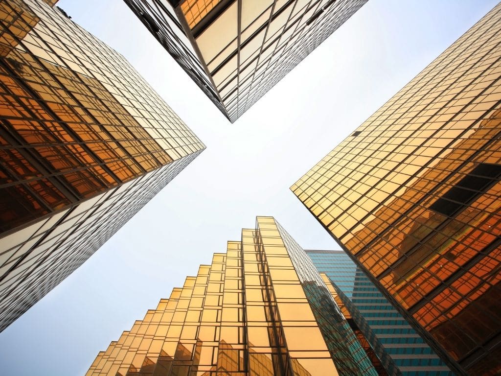 four corner buildings at intersection looking at sky