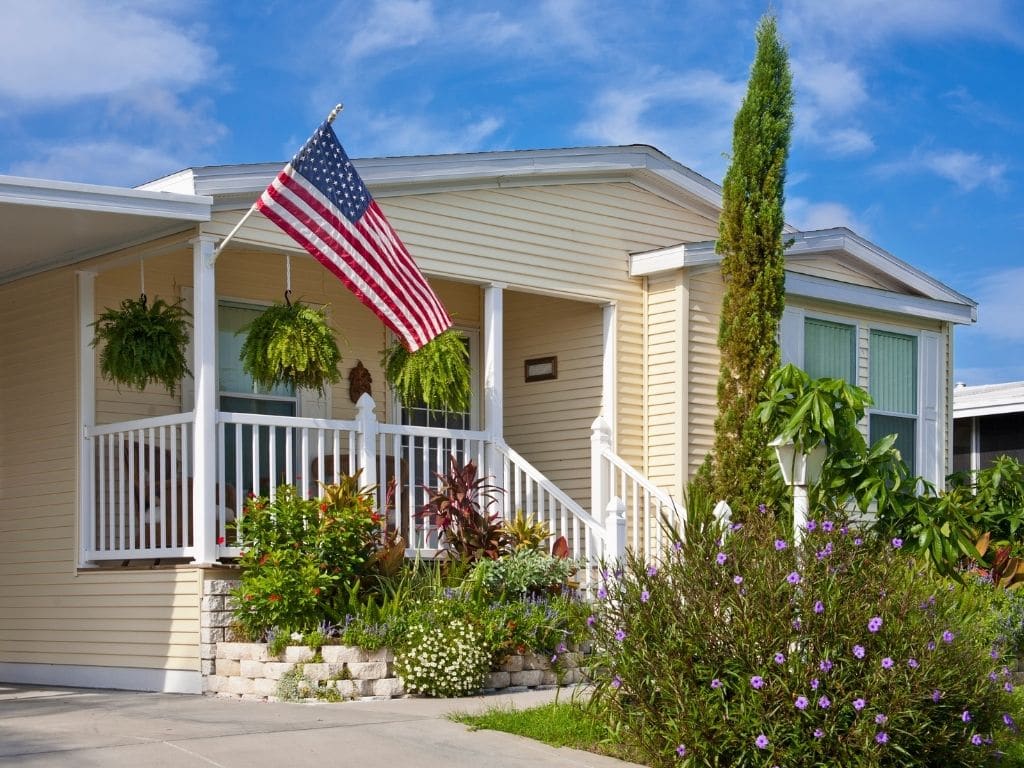mobile home with american flag on blue sky day