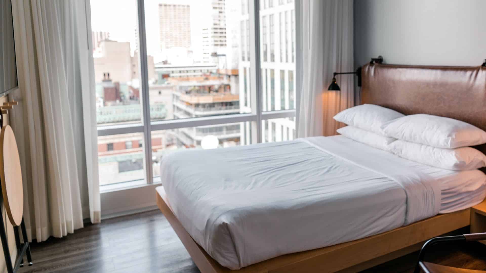 A White Linen on the Bed Near the Glass Window with a View